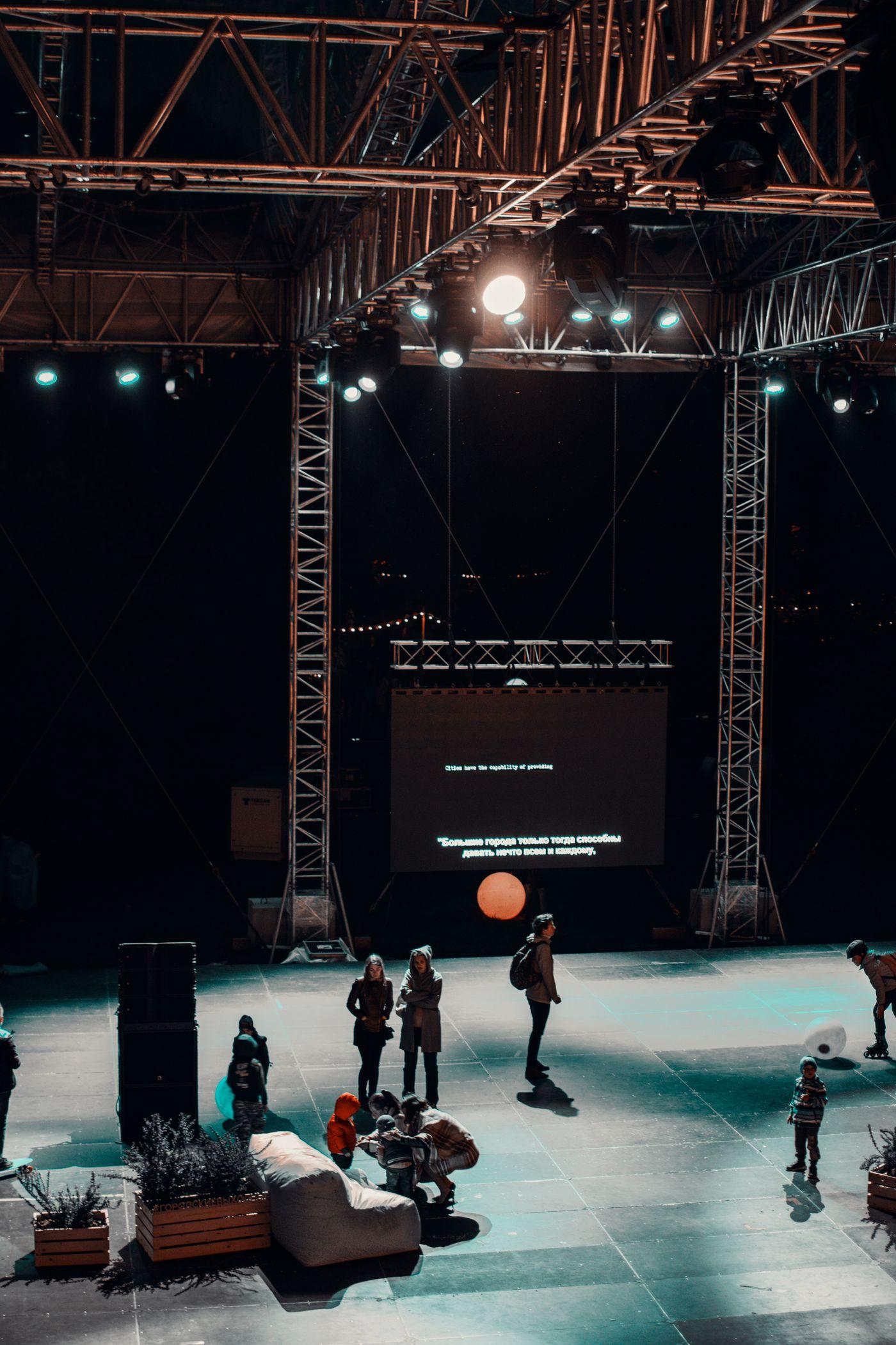 A stage and screen being prepared before an evening event.