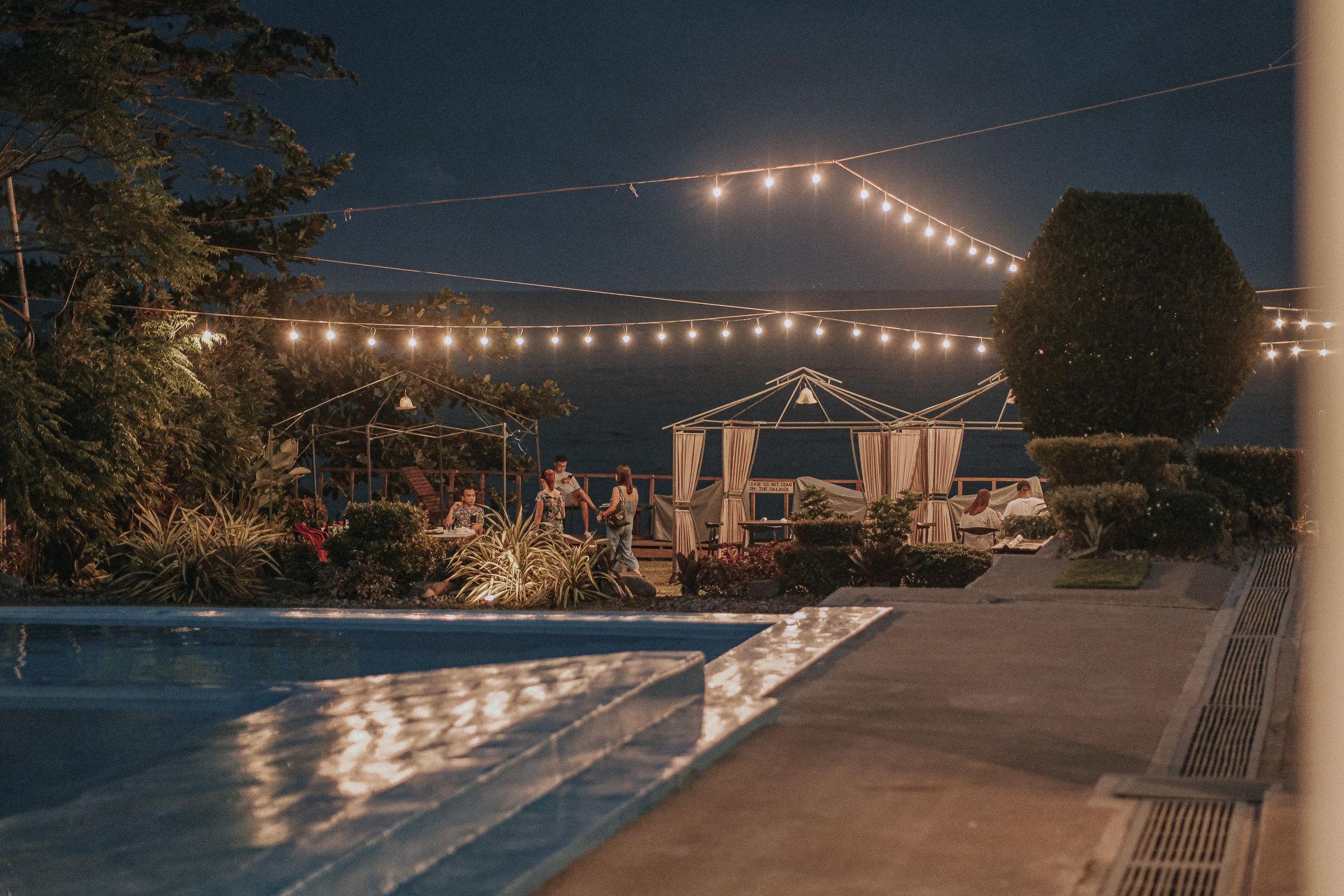 An evening poolside gathering under string lights.